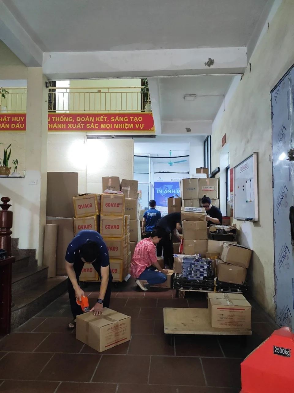 Nhân viên đóng gói ấn phẩm vào thùng carton tại xưởng